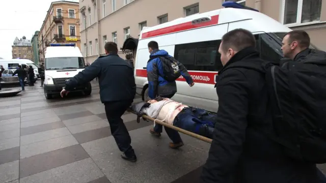 Спасатели несут на носилках пострадавшего от взрыва