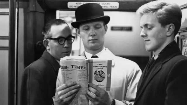 Des hommes lisant un journal.