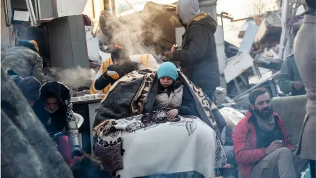 عامل إنقاذ يستريح بجوار مبنى مهدم بفعل الزلزال في محافظة هاتاي التركية