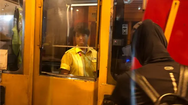 香港九龙红磡海底隧道收费广场一名收费员展现无奈表情（10/8/2019）