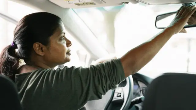 કાર ચલાવતી મહિલાનો ફોટોગ્રાફ