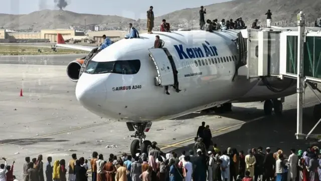 اوت ۲۰۲۱ و مردمی که به امید فرار از کابل از هواپیمایی در فرودگاه کابل بالا میروند