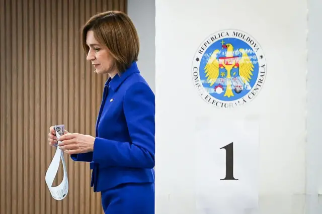 Майя Санду выходит из кабинки для голосований