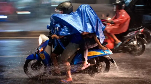 Motor melintas di tengah hujan.