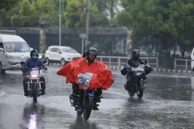 वर्षामा मोटरसाइकल चलाउँदै