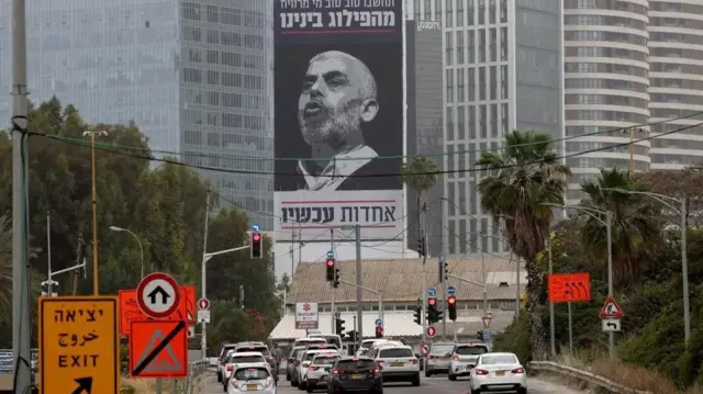 Magari huko Tel Aviv yanapita bango la Sinwar, na ujumbe kwa Kiebrania ukiwahimiza Waisraeli kuungana dhidi ya adui wao anayetafutwa sana.