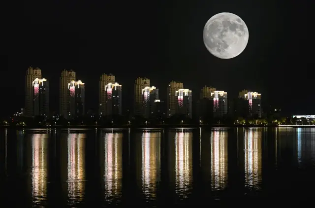 A Lua cheia do Caçador no céu noturno sobre edifícios em 16 de outubro de 2024 em Weihai, na província de Shandong, na China.