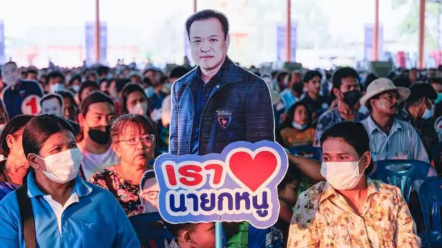 A young supporter of Anutin Charnvirakul, deputy Prime Minister of Thailand and leader of Bhumjaithai party holds a cardboard cut-out of Anutin Charnvirakul, during an event in Nakorn Nayok province. Bhumjaithai party leader Anutin Charnvirakul during a public speaking event at Nakorn Nayok province to introduce the party's policy for people in rural area
