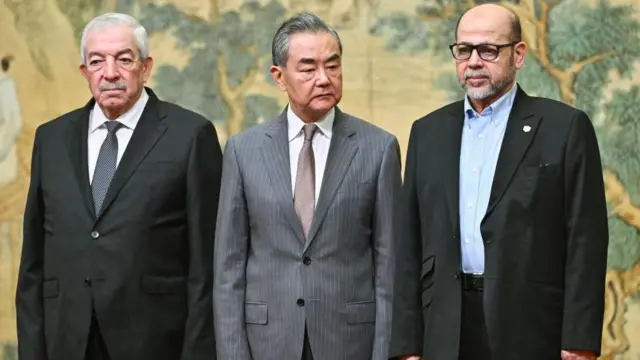 د چین د بهرنیو چارو وزیر وانګ يي (په منځ کې) د فتح مشر محمود العالول (چپ لور) او د حماس لوړپوړي غړي موسی ابو مرزوق سره ګوري.
