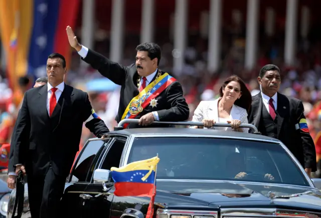 Tổng thống Venezuela Nicolás Maduro và Đệ nhất phu nhân Cilia Flores giữa các cận vệ trước lễ duyệt binh tại Caracas vào ngày 5/3/2014