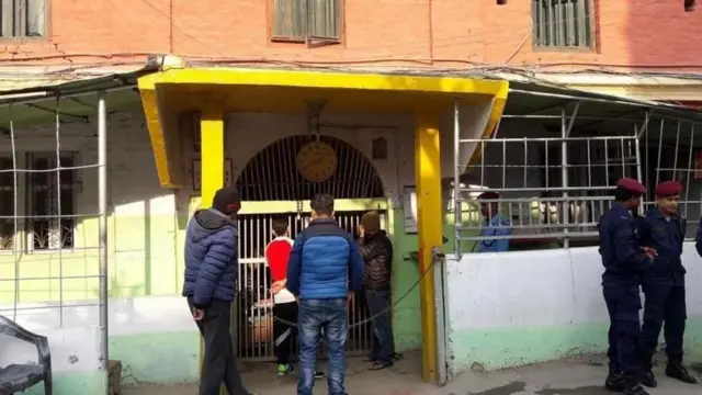 कारागारको ढोकामा मानिसहरू