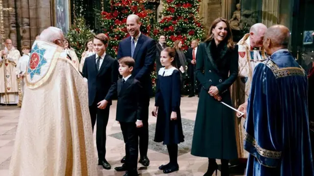 Кетрін та Вільям сміються, а їхні діти слухають, як вони розмовляють з духовенством у Вестмінстерському абатстві