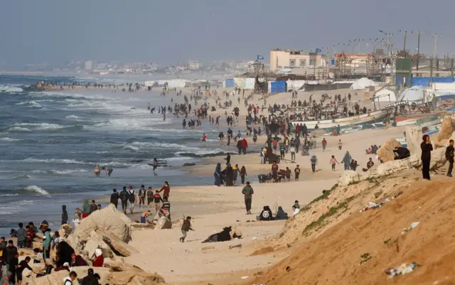 فلسطينيون عند الشاطئ ينتظرون سقوط المساعدات الجوية