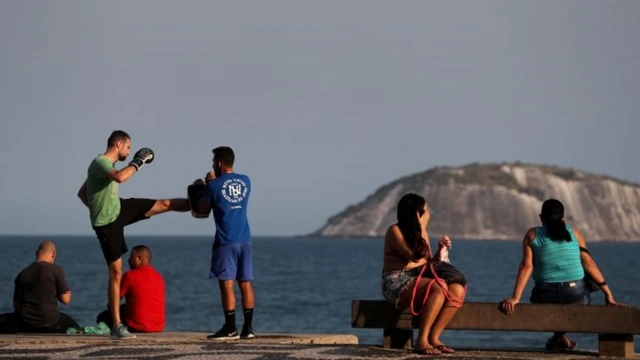 Pessoas sentadasavalon gold slotbancos e praticando lutas no calçadão do Rio