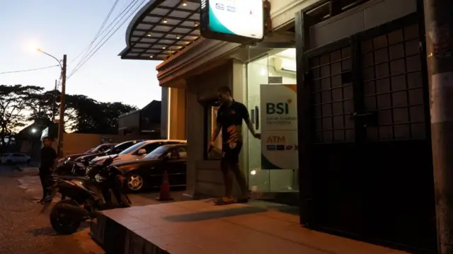 Seorang pria keluar dari ATM BSI di Aceh