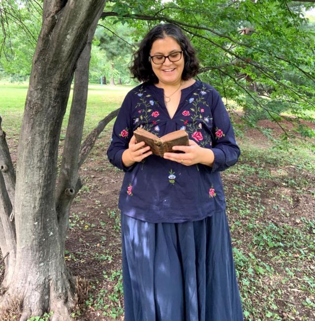 Helen de Cruz leyendo bajo un árbol