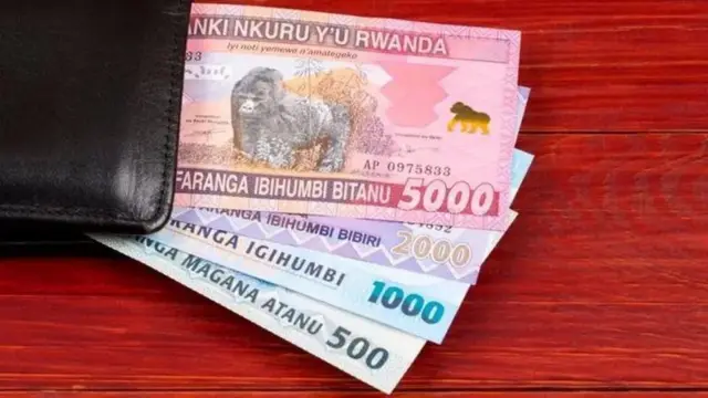 Ifoto igaragaza inoti y'ibihumbi bitanu, iy'ibihumbi bibiri, iy'igihumbi n'iya magana atanu, z'amafaranga y'u Rwanda, zisohotse mu ikofi y'umukara irambitse ku meza. 