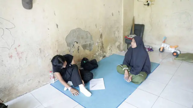 Ruang tengah rumah Hari nampak cat dinding sudah terkelupas dan temboknya terkikis di beberapa sisi. 
