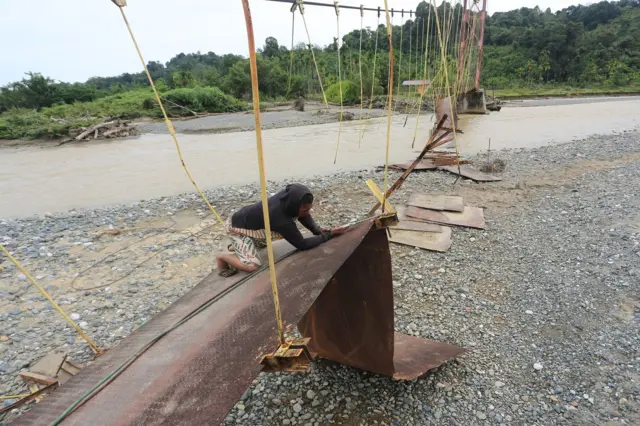 Pekerja menyelesaikan proyek rehabilitasi jembatan gantung penghubung Desa Jambak dan Desa Canggai yang rusak pascabencana banjir bandang di Kecamatan Pante Ceureumen, Aceh Barat, Aceh, Rabu (29/7/2026).