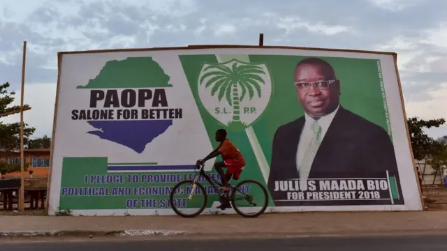ne boy dey ride bicycle pass signboard of candidate Julius Maada Bio