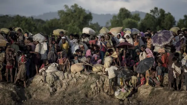 shows Rohingya refugees wait after crossing the Naf river from Myanmar into Bangladesh in Whaikhyang on October 9, 2017
