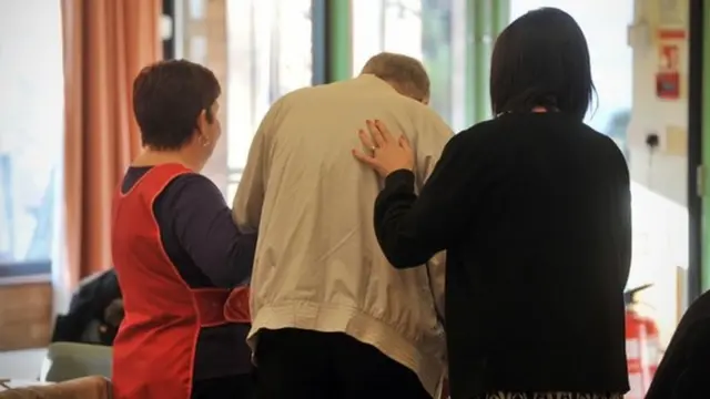 An elderly man being cared for