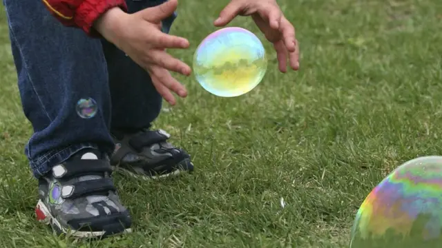 Niño persigue burbujas