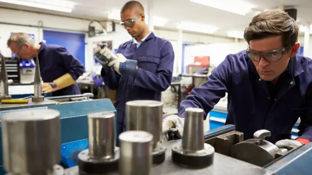 Homens verificam máquinas durante expediente no trabalho