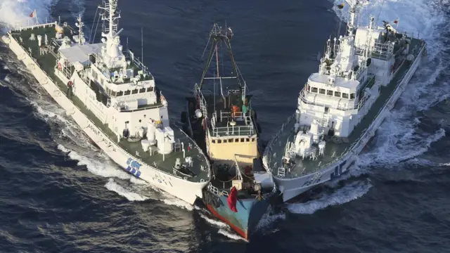 The Boa Diao boat, center, is surrounded by Japan Coast Guard"s patrol boats after Hong Kong activists from Action Committee for Defending the Diaoyu Islands descended from the boat onto Uotsuri Island, one of the islands of Senkaku