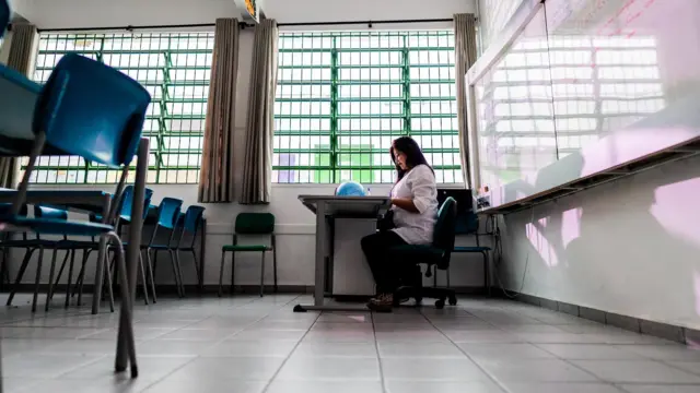 Professora em sala de aula vazia
