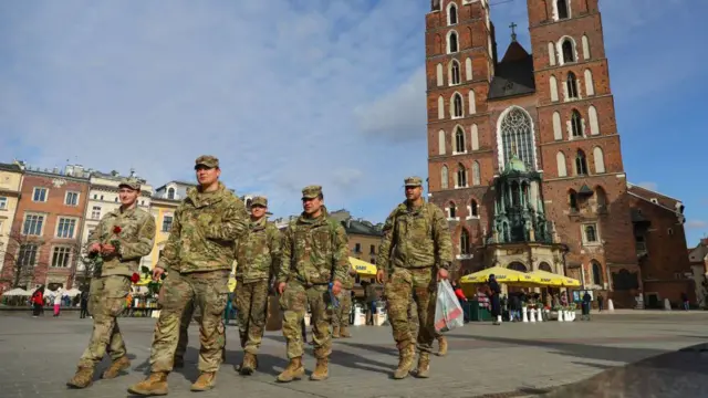 Żołnierze 82. Dywizji Powietrznodesantowej USA podczas wizyty na Rynku Głównym w Krakowie, 8 marca 2022 roku. Wojska amerykańskie przybyły do ​​Polski jako posiłki dla sojuszników z NATO w Europie Wschodniej, w tym dla Polski, w związku z rozpoczęciem rosyjskiej inwazji na Ukrainę. (Zdjęcie: Beata Zawrzel/NurPhoto via Getty Images)