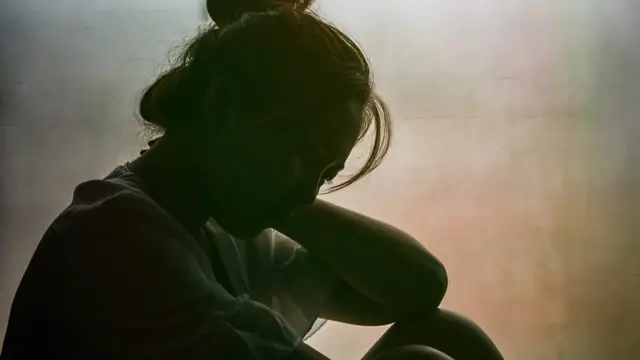 ጥላ ውስጥ የምትታይ ሴት