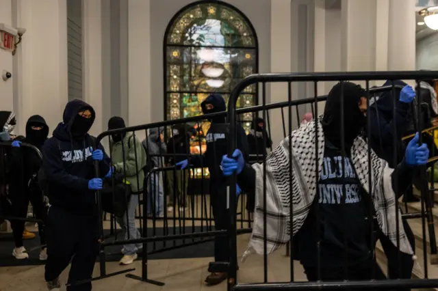 Manifestantes cargando con vallas dentro del Hamilton Hall.