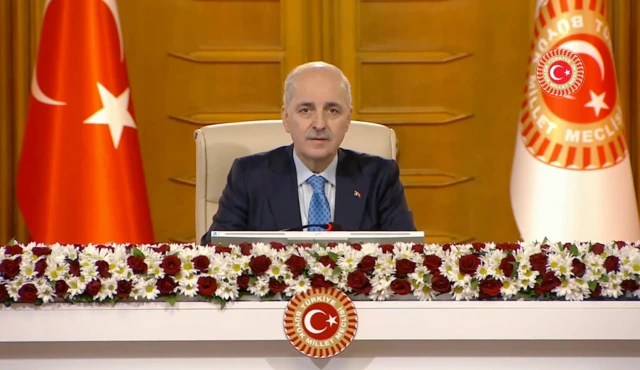 TBMM Başkanı Numan Kurtulmuş kürsüde konuşuyor. Yanında Türk bayrağı ve TBMM bayrağı var
