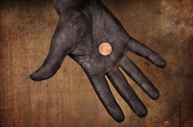 Une main tenant une pièce d'un Euro