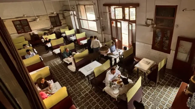 نمایی از بالا، داخل یک رستوران و چند نفر در حال خوردن غذا