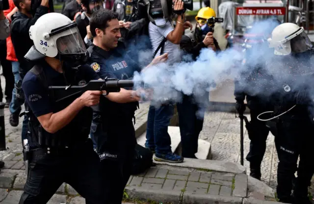 Biber gazıyla göstericilere müdahale eden bir polis