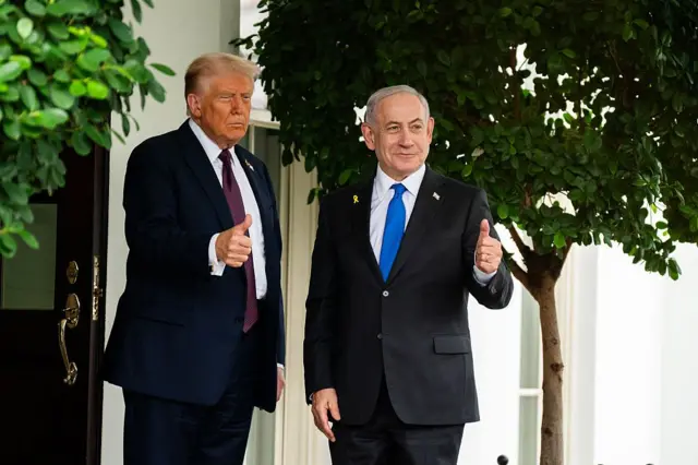 Donald Trump (d) y Benjamin Netanyahu (i) alzan el pulgar a la entrada de la Casa Blanca. 