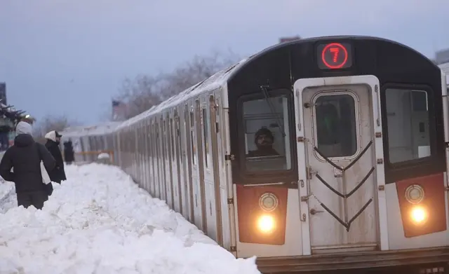 Yolcuların beline kadar gelen karla dolu bir tren istasyonu