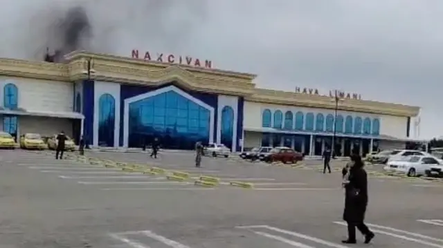 Фасад здания аэропорта Нахичевани, за которым поднимается черный дым