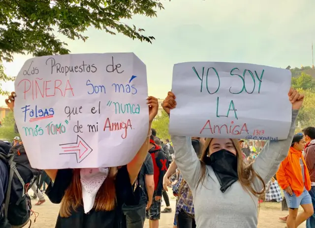 Dos mujeres sostienen carteles