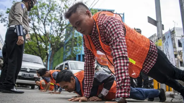 Satgas gabungan memberi hukuman push-up kepada warga yang tidak memakai masker di Jalan Jenderal Sudirman, Palembang, Sumatera Selatan, Rabu (16/09).