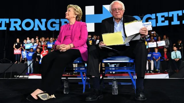 Hillary Clinton e Bernie Sanders sentados, à espera do iníciojogos casanikum debate