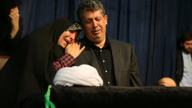 Fatemeh Hashemi, daughter of Iran"s former President Akbar Hashemi Rafsanjani, places her head on the shoulder of her brother Mahdi while they mourn over the coffin of their father, at the Jamaran mosque in northern Tehran