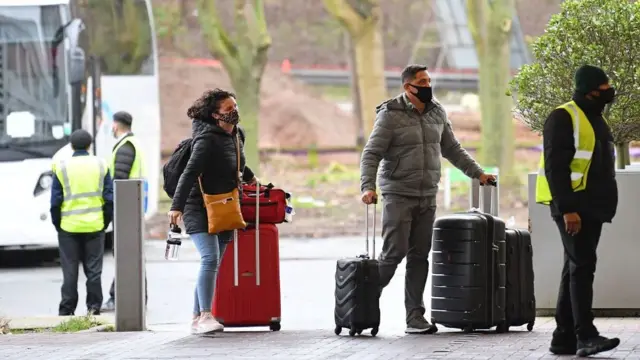 লাল তালিকাভূক্ত দেশ থেকে আসা এক দম্পতিকে কোয়ারেন্টিন সেন্টারে নেয়া হচ্ছে।