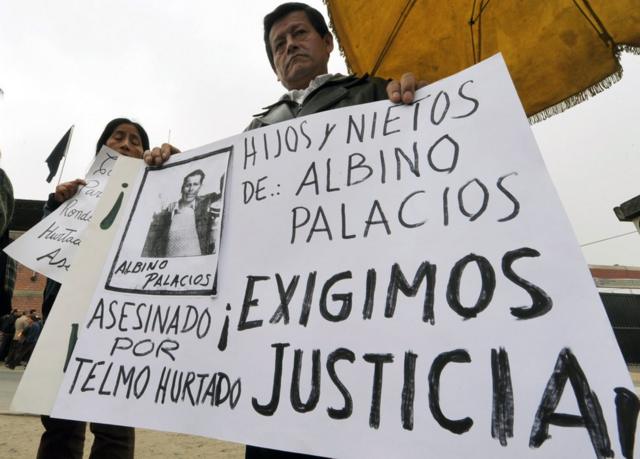 Familiares de víctimas sujetan carteles y exigen justicia por el caso Accomarca en 2010.
