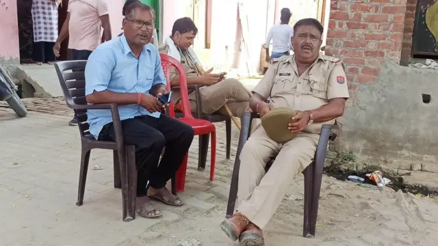 मृतका के घर के बाहर बैठे लोग