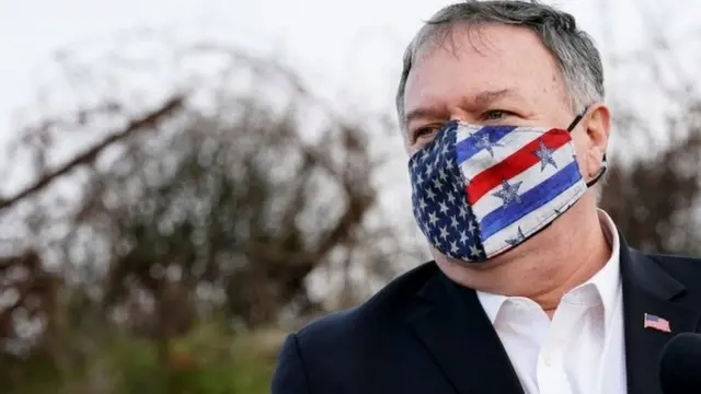 Mike Pompeo wearing a face mask with a US flag on it, standing in the occupied Golan Heights