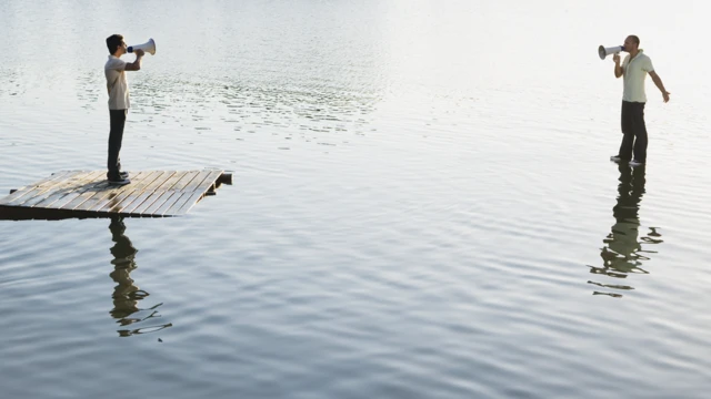 Deux hommes debout sur l'eau avec des mégaphones.