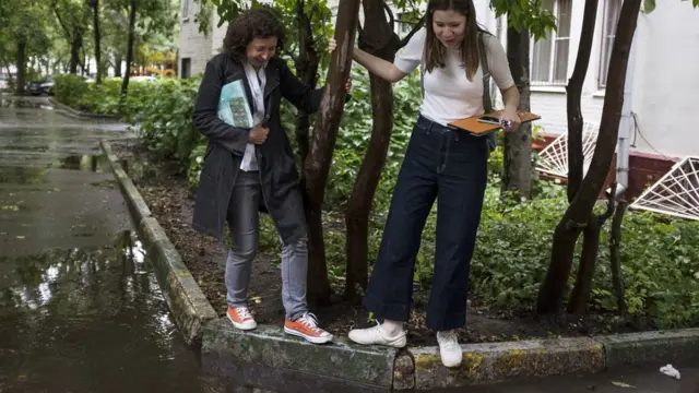 Кандидатки пробираются мимо луж во дворах